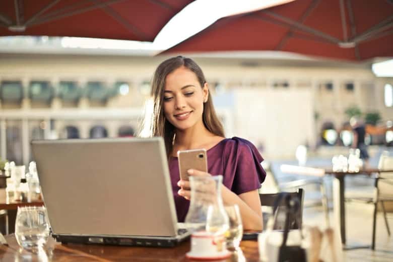 Osoba analizująca wyniki kampanii reklamowej na laptopie i smartfonie